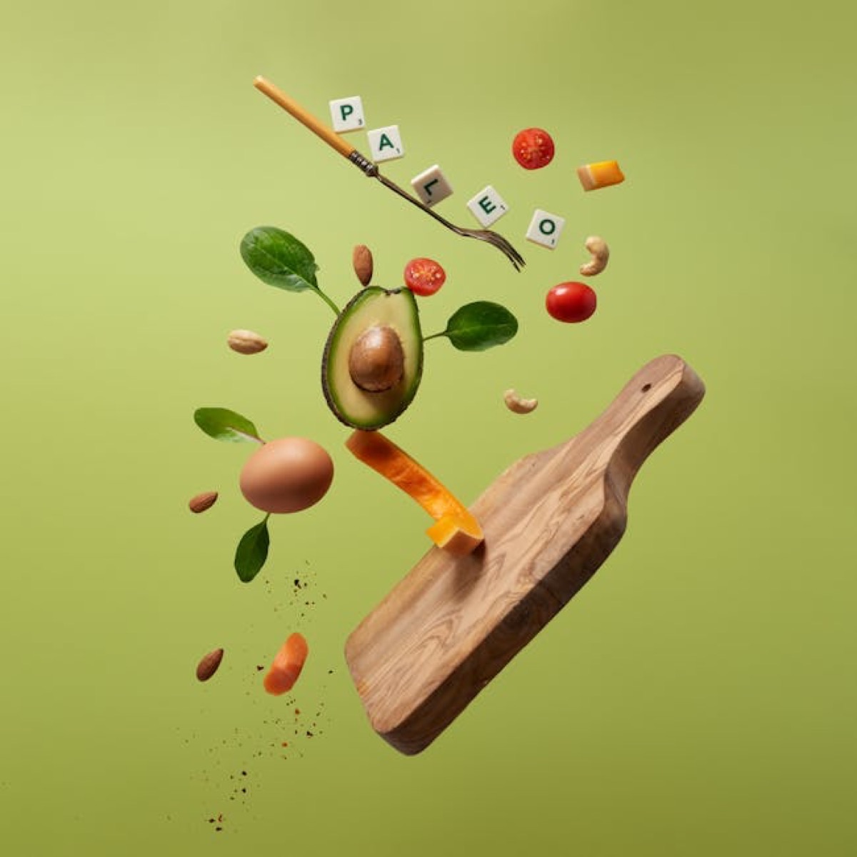 Assiette paléo composée de viande grillée, de légumes verts, de noix et de baies fraîches sur une table en bois